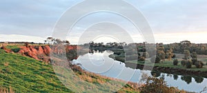 long stretching bend in a river that flows past red rock cliffs and into the ocean at Werribee south during golden hour, Victoria