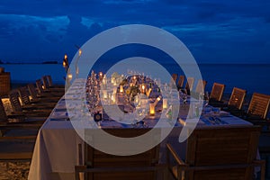 Long table wedding dinner setup on the beach.