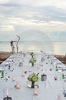 Long table wedding dinner setup on the beach.