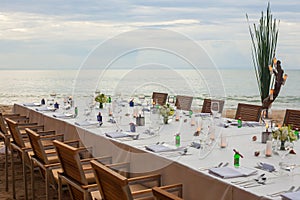 Long table wedding dinner setup on the beach.