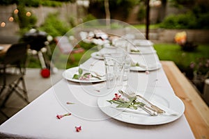 a long table with a white cloth covered with plates, silverware and forks