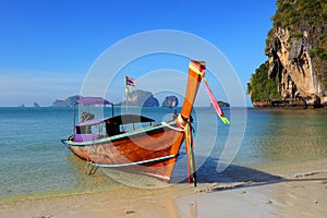 Long tail boat on tropical beach (Pranang beach) and rock, Krabi, Thailand