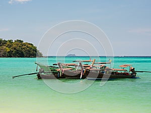 Long tail boats with crystal clear water in sunny day