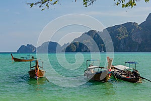 Long-tail boats parked in the bay at the tropical beach in Thailand. Phi Phi