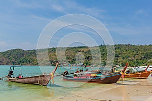 Long-tail boats parked at the tropical beach in Thailand. Phi Phi. Ocean. Sunny day