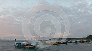 Long-tail fishing boats on Rawai beach at Phuket Thailand in sunrise