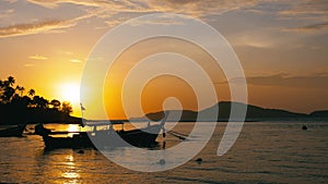 Long-tail fishing boats on Rawai beach at Phuket Thailand in sunrise