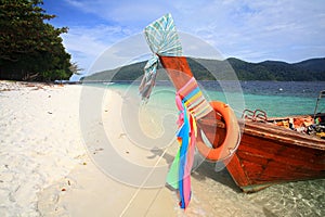 Long tail wooden boat with colorful ribbons