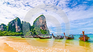 Long tailed boats at famous Railay beach. Boats prepared for tourists from beautiful Thailand beach. Pure blue water with