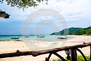 Long tailed boats near tropical beach at Ko Phi Phi, Thailand. Tropic beach with white sand and turquoise water, concept of