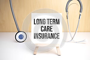 Long Term Care Insurance sign on small wood board rest on the easel with medical stethoscope