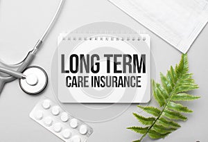 Long Term Care Insurance word on notebook,stethoscope and green plant