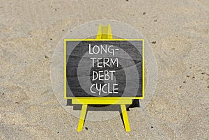 Long-term debt cycle symbol. Concept words Long-term debt cycle on beautiful black chalk blackboard. Beautiful sand beach