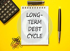 Long-term debt cycle symbol. Concept words Long-term debt cycle on beautiful white note. Beautiful yellow background. Calculator.