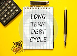 Long term debt cycle symbol. Concept words Long term debt cycle on beautiful white note. Beautiful yellow background. Calculator.