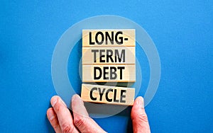 Long-term debt cycle symbol. Concept words Long-term debt cycle on beautiful wooden block. Beautiful blue table blue background.