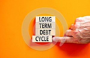 Long term debt cycle symbol. Concept words Long term debt cycle on beautiful wooden block. Beautiful orange table orange