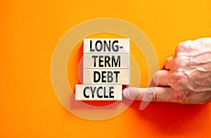 Long-term debt cycle symbol. Concept words Long-term debt cycle on beautiful wooden block. Beautiful orange table orange