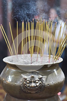 Long thin candles with incense in a special vessel
