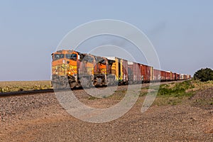 Long train across Texas with orange locomotives photo