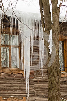 Long transparent icicles hang from the edge of the roof.