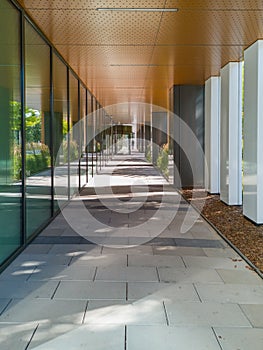 Long tunnel with pillars next to new modern corporate building