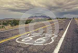 Long US road with a Route 66 sign painted on it