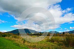 Long white cloud spreading over banks of Tongariro river on a bright autumn day.