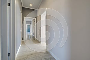 Long white empty corridor in interior of entrance hall of modern apartments, office or clinic