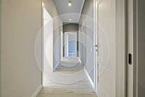 Long white empty corridor in interior of entrance hall of modern apartments, office or clinic