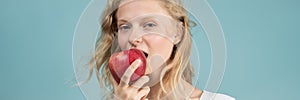 Long width banner with portrait of young woman bitting apple. Fresh face, natural beauty,