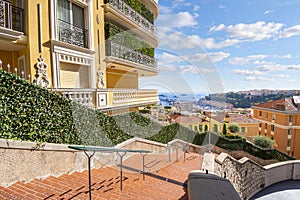 A long, winding staircase connecting different levels of homes and apartments on the steep hillside of Monte Carlo, Monaco