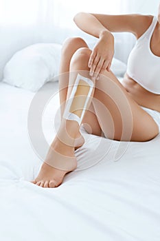 Long Woman Legs With Hair Wax Strip Closeup. Hair Removal
