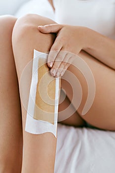 Long Woman Legs With Hair Wax Strip Closeup. Hair Removal