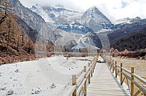 Long wood bridge to Pearl Lake with landscape Holy snow Mountain at Yading winter season in Daocheng ,China,Beautiful Nature Trav