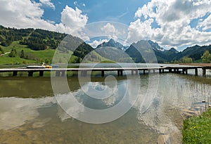 Long wooden boardwalk on a calm and placid mountain lake with a great view