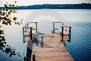 Long wooden pier and beautiful lake Saimaa, Finland on warm and windless summer day.