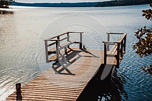 Long wooden pier and beautiful lake Saimaa, Finland on warm and windless summer day.