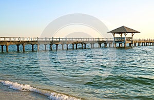 Long wooden pier on the blue windy sea