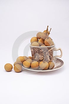 Longan fruit in mug on white background.  In Indonesia it is commonly called Kelengkeng