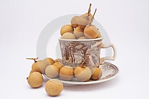 Longan fruit in mug on white background.  In Indonesia it is commonly called Kelengkeng