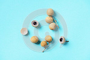 Longan fruits on blue background. Top view. Copy space. Dimocarpus longan. Bunch of exotic longans. Tropical food concept