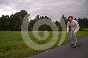 Longboarder going up the hill with speed, horizontal shot with copy space