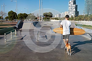 Longboarder in skate park with his dog