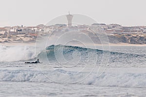 Longboarder surfing perfect small waves in Peniche