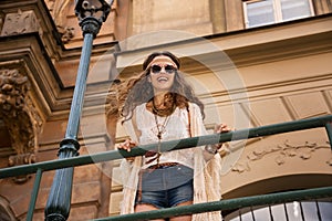 Longhaired boho chic with sunglasses near old town streetlight