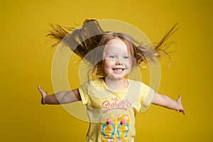 Longhaired girl in cute shirt playing with hair and twirling