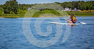 Longhaired girl paddles across pond in Martha`s Vineyard.jpg