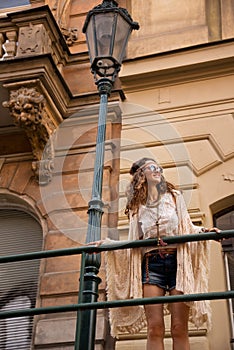 Longhaired hippy lady with sunglasses near old town streelight