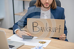 Longhaired man with placard in the office